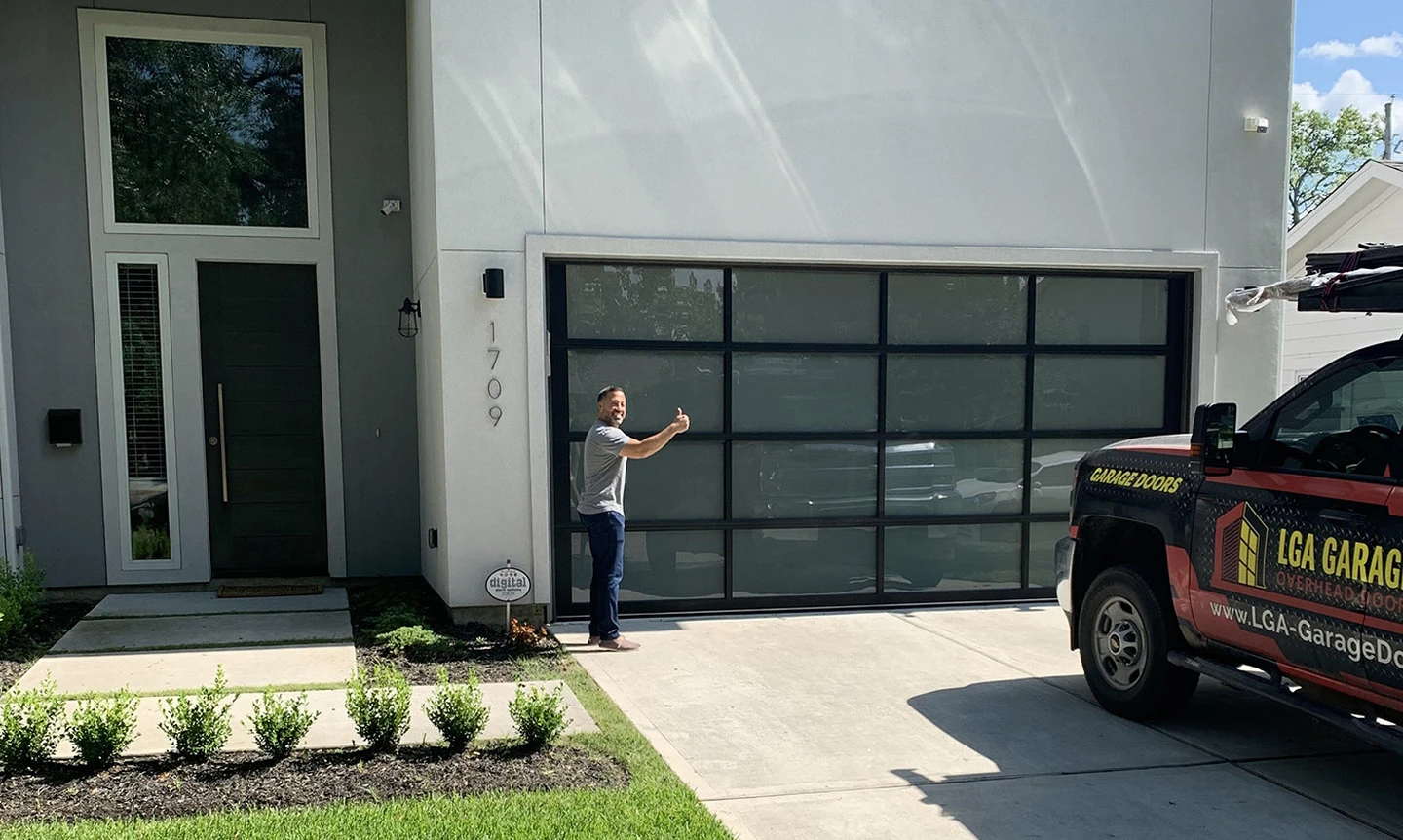 Full view aluminum glass garage door with a very happy customer