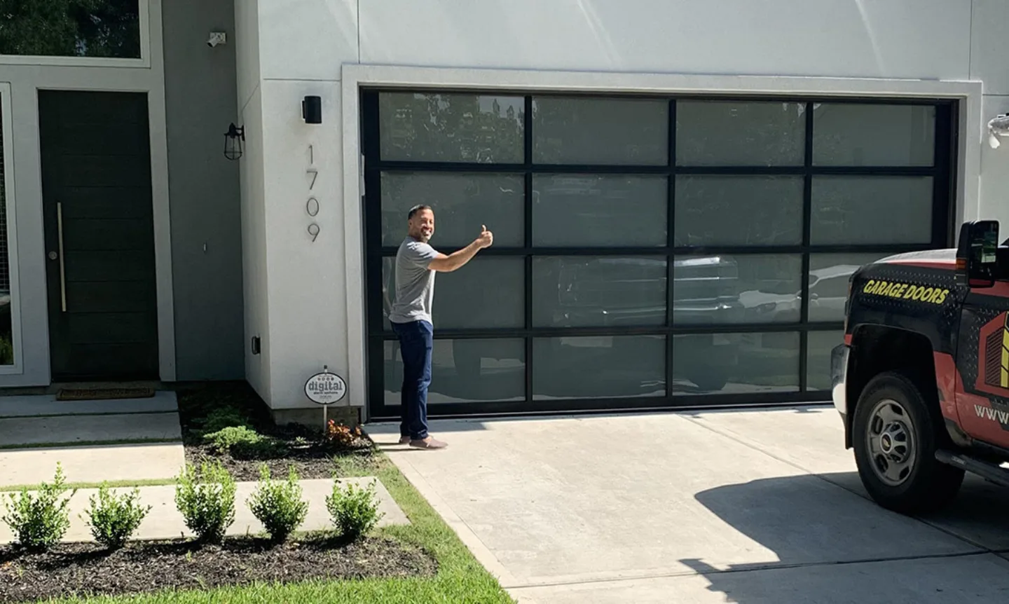Full view aluminum glass garage door with a very happy customer